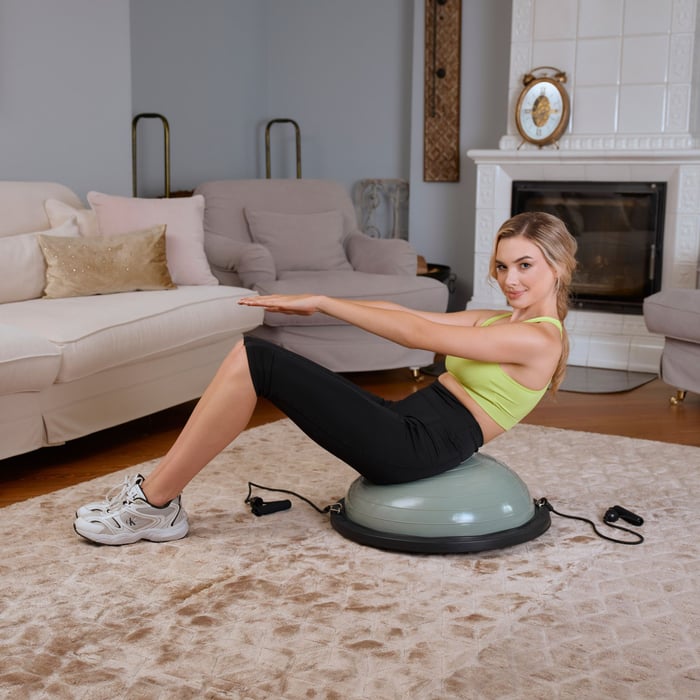 Frau trainiert mit dem Hop-Sport salbeigrun Balance Trainer – Bauchmuskelübungen