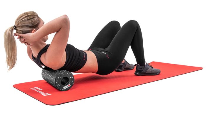 Selbstmassage bei Schmerzen – gezielt Druck ausüben mit der Trainingsrolle für wohltuende Entspannung.